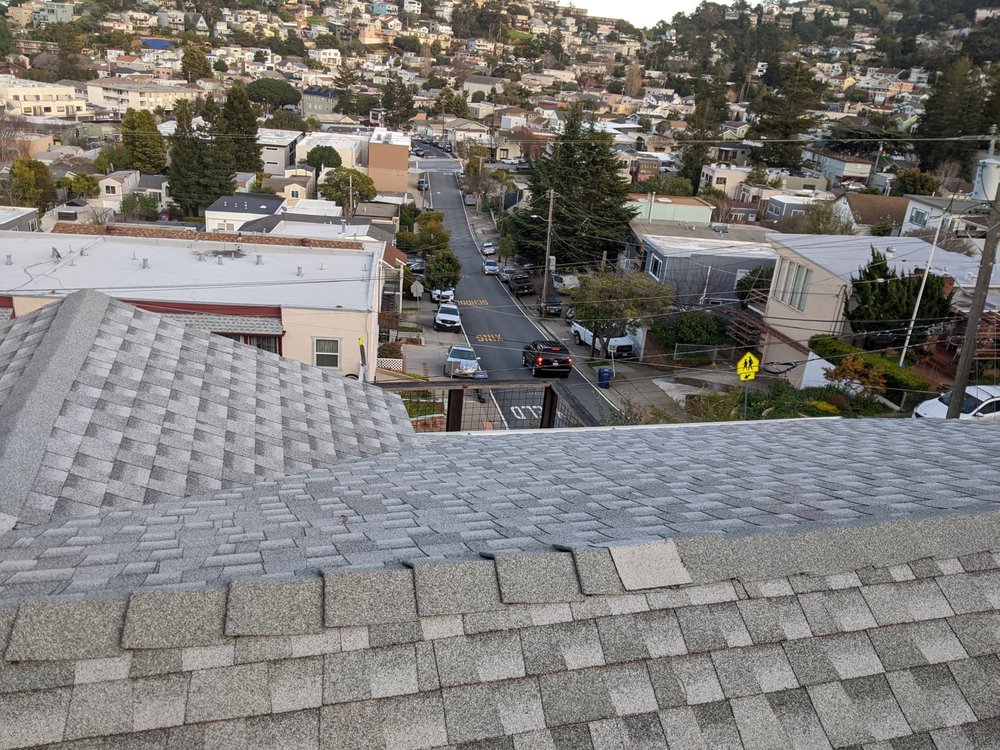 Light gray steep-slope shingle roof replacement next to a neighboring low-slope roof in Capitola, CA